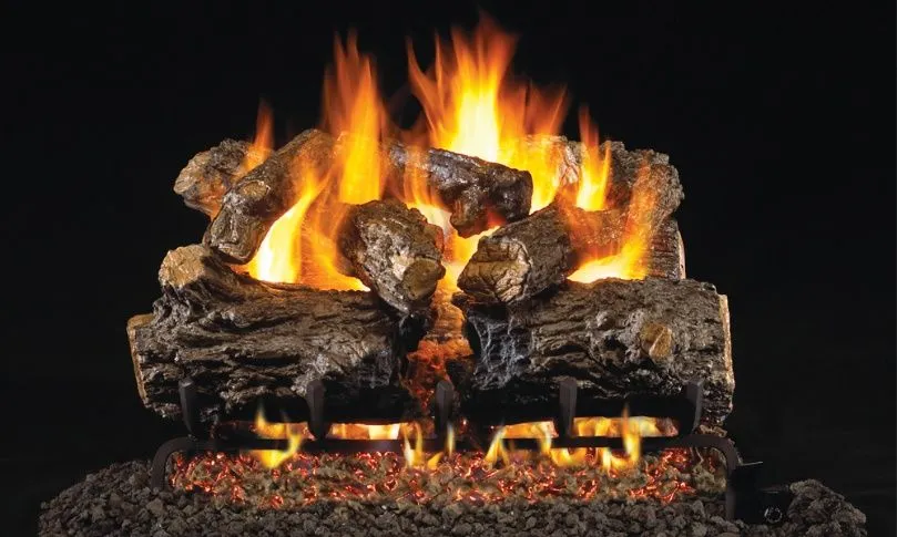 Burning gas fireplace with ceramic logs. Flames and glowing embers against a dark background.