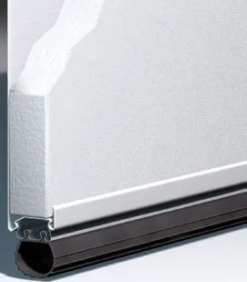 White garage door cross-section showing insulation and a dark rubber seal.
