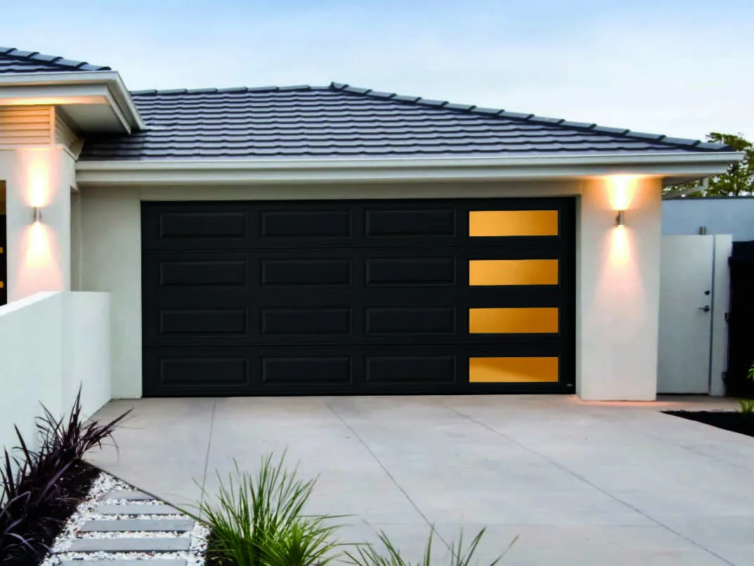 Black garage door with rectangular windows, tan trim, concrete driveway, white house exterior.