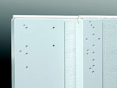A close-up view of two white metal garage door panels featuring vertical mounting brackets with mult…