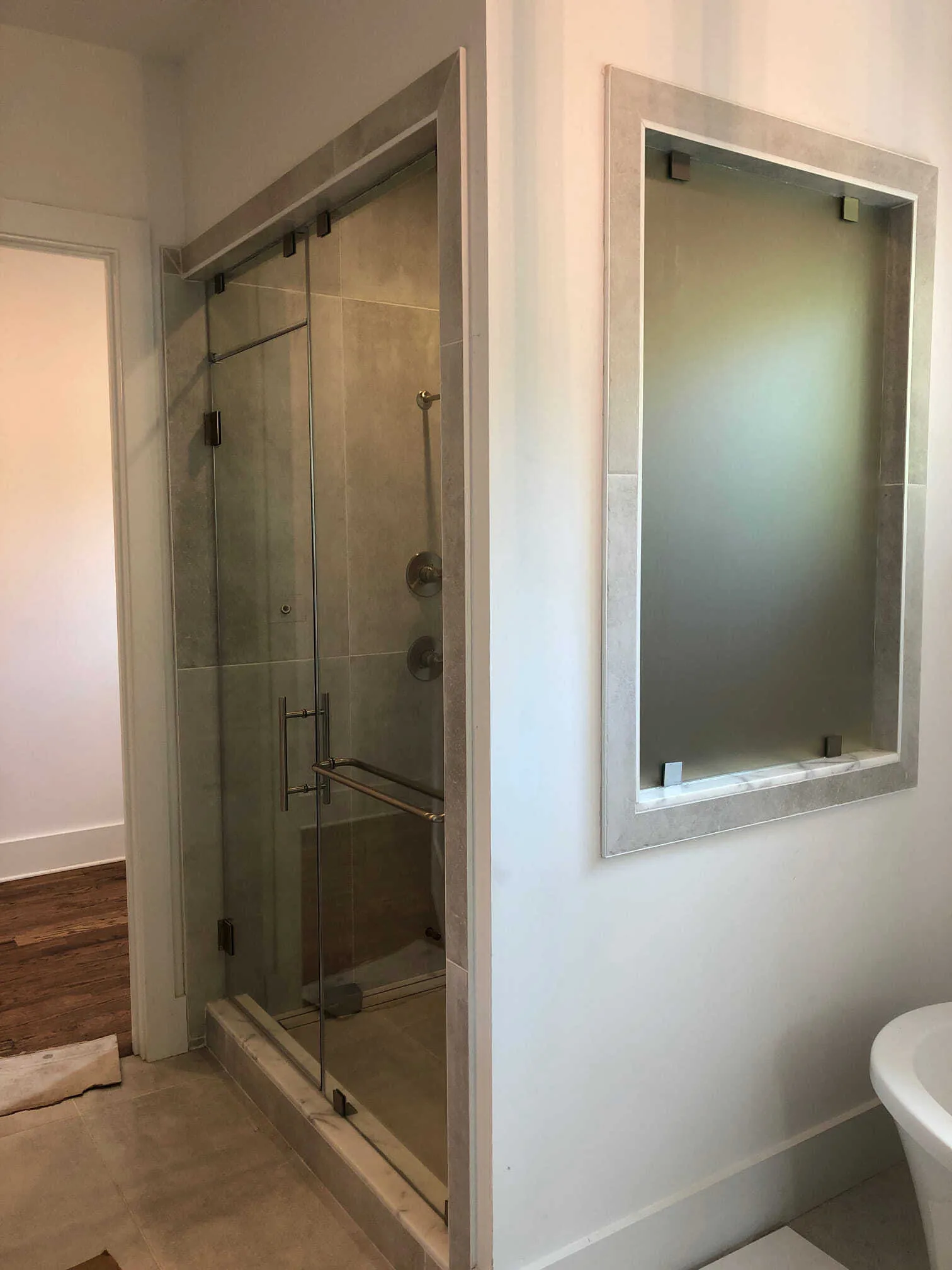 Bathroom with corner shower, beige tiles, dark brown vanity, and black shower fixtures.