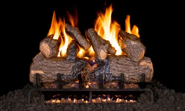 Burning gas fireplace logs with flames, in a dark setting.