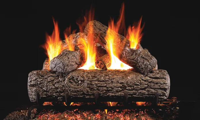 Burning gas fireplace logs with orange flames against a dark background.