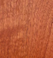 Close-up of reddish-brown wood grain with vertical streaks and darker areas.